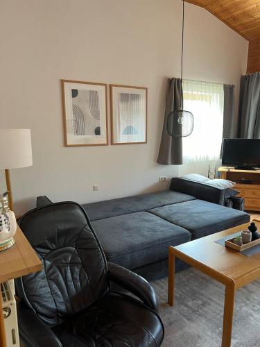 a living room with a couch and a chair at Ferienwohnung Markt Eging am See Bayerischer Wald in Eging am See