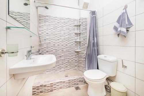 a bathroom with a toilet and a sink and a shower at Silia apartments1 in Ampavris