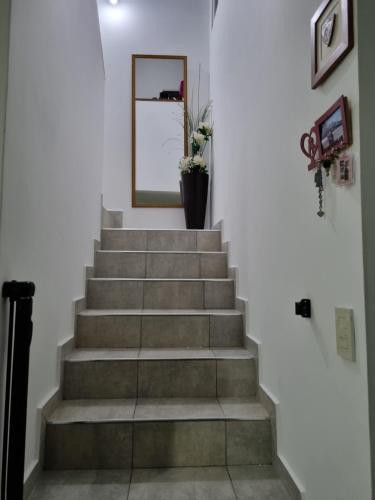 a stairway with a mirror and a vase of flowers at LyL in Posadas Aeroclub