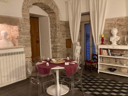 a dining room with a table and some statues in it at Palazzo Siena De Facendis in Bitonto