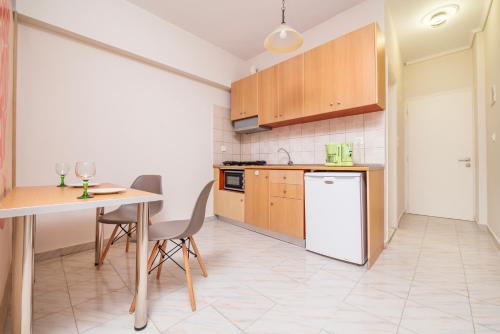 a kitchen with a table and a white refrigerator at Silia apartments1 in Ampavris