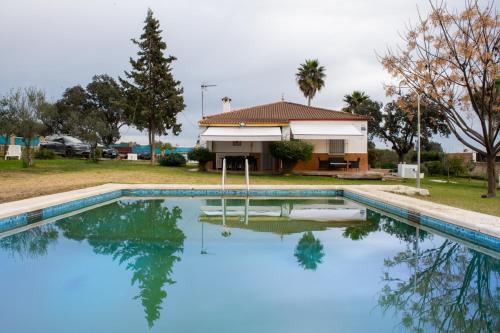 una casa con piscina di fronte a una casa di La Platea Rural a Siviglia