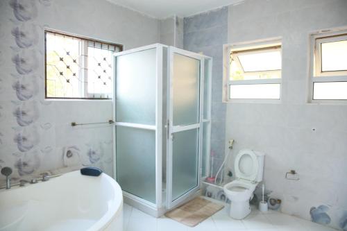 a bathroom with a shower and a toilet at Nyali Fully Furnished Rooms and Apartments in Mombasa