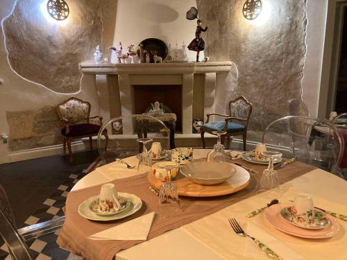 a dining room with a table and a fireplace at Palazzo Siena De Facendis in Bitonto
