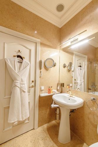 a bathroom with a sink and a shower and a mirror at NARUTIS Hotel - Small Luxury Hotels of The World in Vilnius