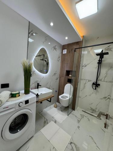a bathroom with a washing machine and a toilet at AmyMamaia marina blue in Mamaia