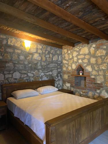 a bedroom with a large bed in a stone wall at Pavelin Yeri Otel in Edremit