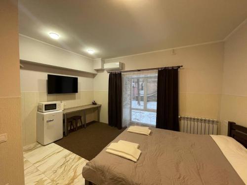 a bedroom with a bed and a desk with a microwave at Апартаменти в центрі міста in Poltava