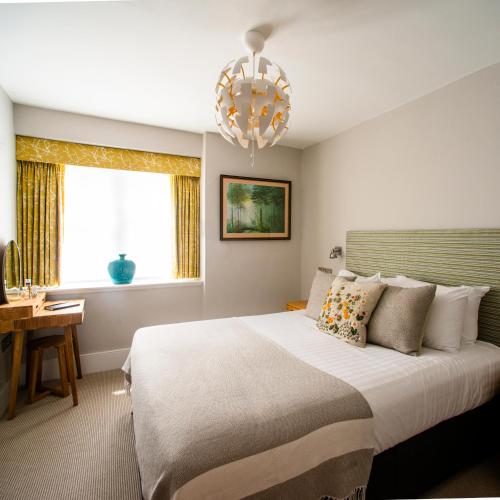 a bedroom with a large bed and a chandelier at The Porlock Weir Hotel in Porlock