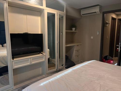 a bedroom with a flat screen tv in a mirror at Apartemen grand jati junction in Medan
