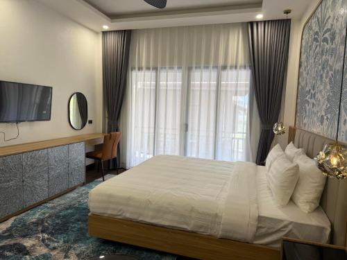 a hotel room with a bed and a television at Dawn Boutique Luangprabang Hotel in Luang Prabang
