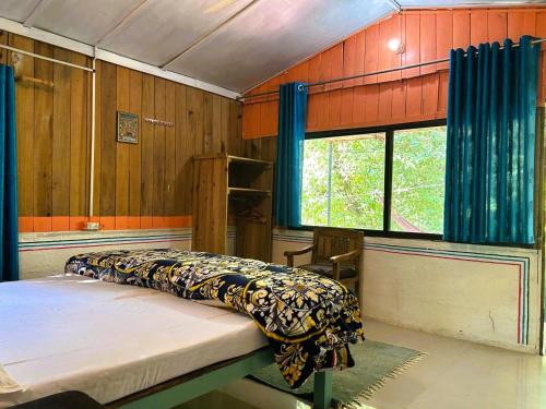 a bedroom with two beds in a room with wooden walls at Rishikesh Valley in Rishīkesh