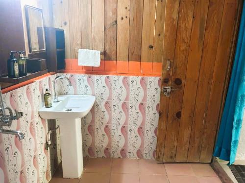 a bathroom with a sink and a wooden wall at Rishikesh Valley in Rishīkesh