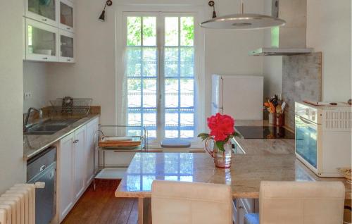 une cuisine avec une table avec un vase de fleurs dans l'établissement Amazing Home In Sainte-Marguerite-Sur-, à Sainte-Marguerite