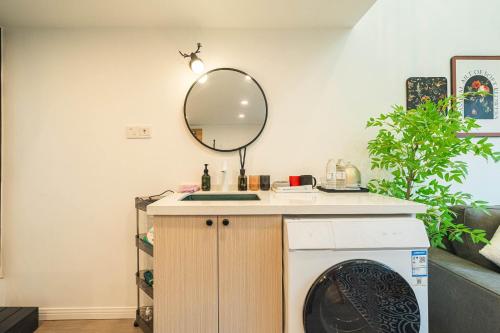 a bathroom with a washing machine and a mirror at 柃居 B&B - Jing'an Temple Branch in Shanghai
