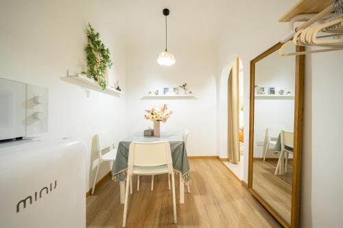 a dining room with a table and chairs and a mirror at 柃居 B&B - Jing'an Temple Branch in Shanghai