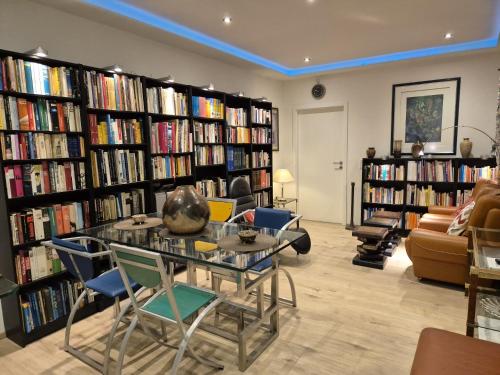 a library with a table and chairs and books at Immotal24 in Wuppertal