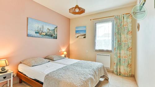 une chambre avec un lit et une fenêtre dans l'établissement Maison Oceane, à Saint-Hilaire-de-Riez