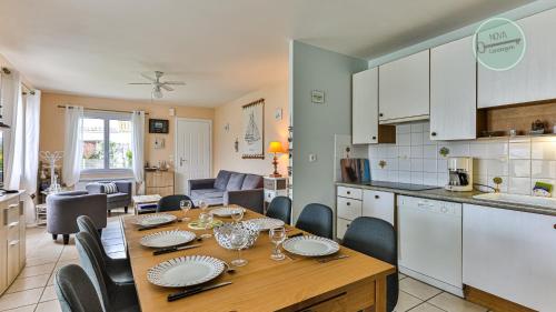 une cuisine et une salle à manger avec une table et des chaises dans l'établissement Maison Oceane, à Saint-Hilaire-de-Riez