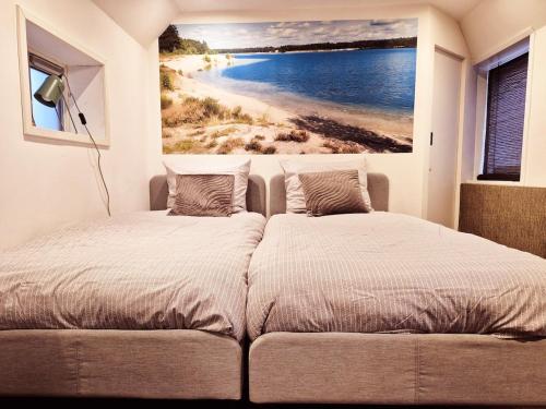 a bedroom with a bed and a painting of a beach at Ons kleine huisje in Gasselte