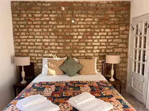 a bedroom with a brick wall and a bed with two lamps at Snug Houseguests in Lisbon