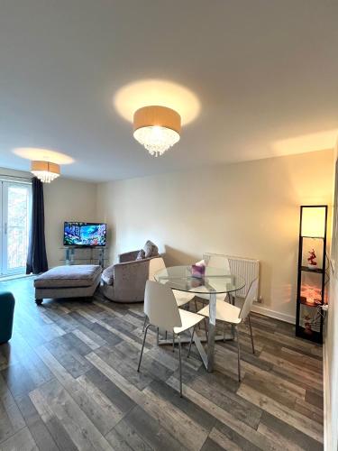 a living room with a glass table and chairs at Spacious two bedrooms apartment for business and holiday in Portsmouth