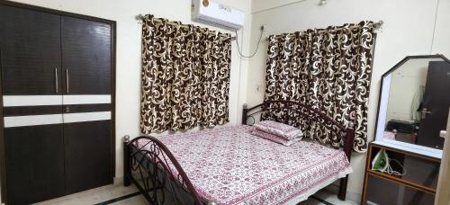 a small bedroom with a bed and a mirror at Homely Stay in Kolkata