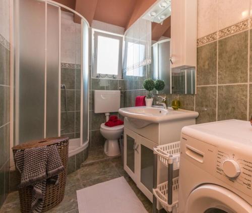 a bathroom with a sink and a washing machine at Apartment Julia A1 in Biograd na Moru