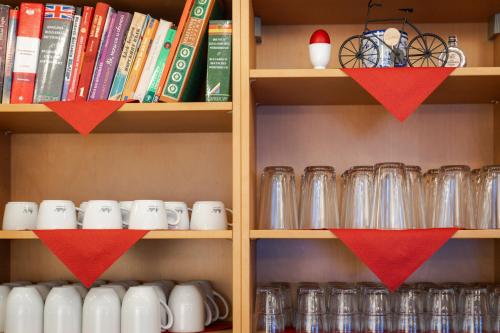 a book shelf filled with cups and books at Hotel Valerie in Saalbach Hinterglemm