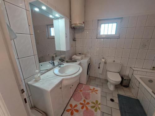 a white bathroom with a sink and a toilet at River House in Kalabaka