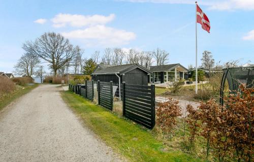 a fence on the side of a road next to a house at Nice Home In Strøby With Wifi in Strøby