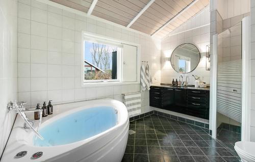 a white bathroom with a tub and a sink at Nice Home In Strøby With Wifi in Strøby