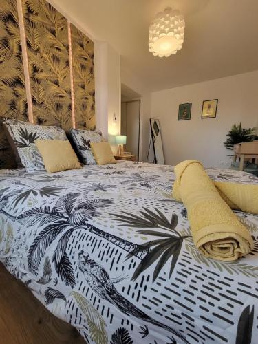 a bedroom with a large bed with a black and white blanket at Maison Althéa - Calme, Spa & Extérieur plein sud in Lempty
