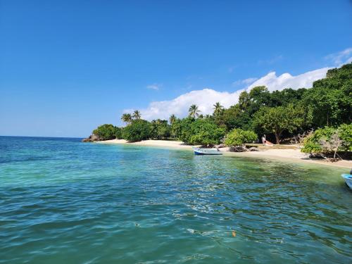 a beach with two boats in the water at Room for 2 w kitchen pool close to the beach in Las Galeras