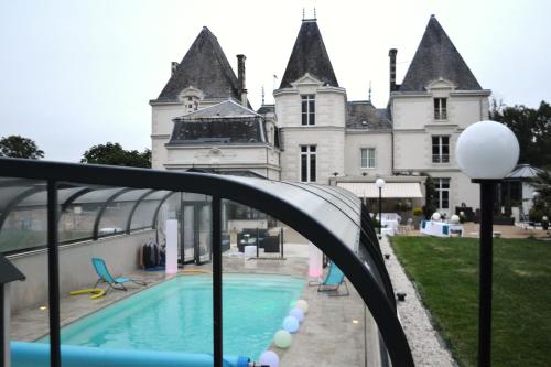 a swimming pool in front of a castle at Le Domaine du Chêne Vert in Château-Gontier