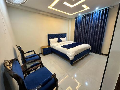 a bedroom with a bed and chairs and a window at Hotel Summer Palace Murree in Murree