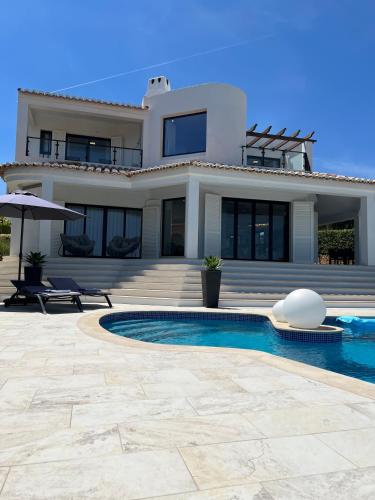 a house with a swimming pool in front of a house at Seafront View next to the famous “Benagil Caves” in Benagil