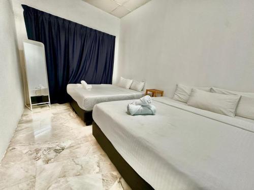 a hotel room with two beds and a window at The Yew Homestay in Teluk Intan