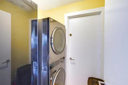 a bathroom with a washer and dryer next to a door at Cozy Mountain Home in the Catskills - Fall Views & Trails in Elka Park