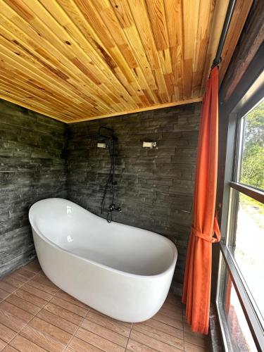 a bath tub in a bathroom with a wooden ceiling at Oksijen Suit in Çamurlu