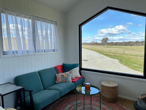a living room with a couch and a large window at Belle Barn in Murrumbateman