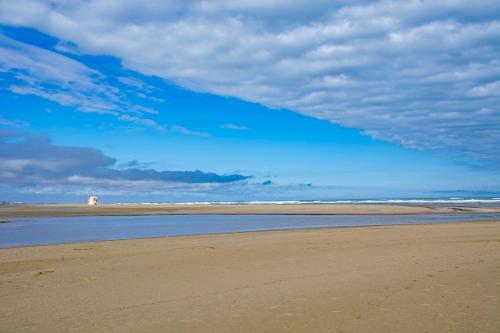 a beach with a blue sky and some water at T3 de 70m2 avec sauna, piscine intérieure chauffée in Siran