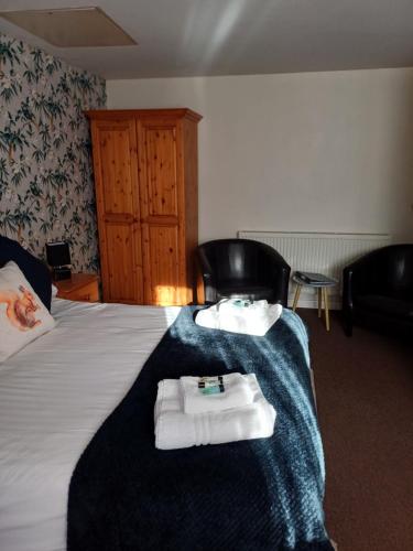 a hotel room with a bed with towels on it at The Queen Victoria in Snettisham