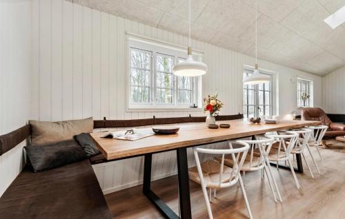 a dining room with a large wooden table and chairs at Stunning Home In Glesborg With Sauna in Glesborg