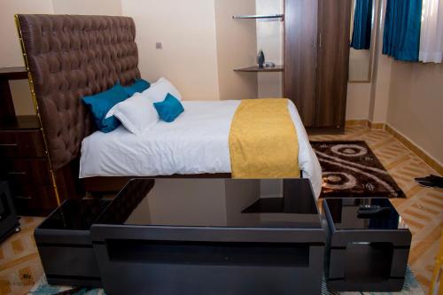 a bedroom with a bed with a glass table at The Ehajis Exclusive Studio Apartment in Elgon View Near Sports Club, Eldoret in Eldoret