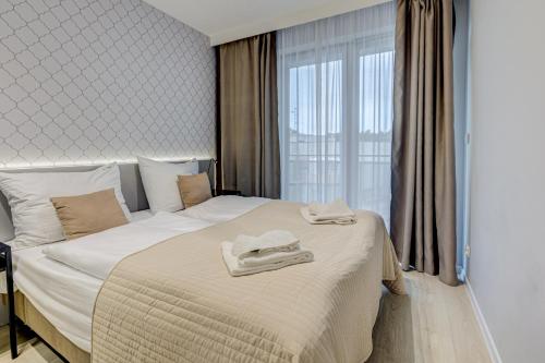 a hotel room with a bed with towels on it at Apartamenty Rondo in Świnoujście