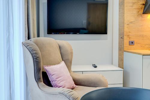 a chair with a pink pillow in a room at Apartamenty Rondo in Świnoujście