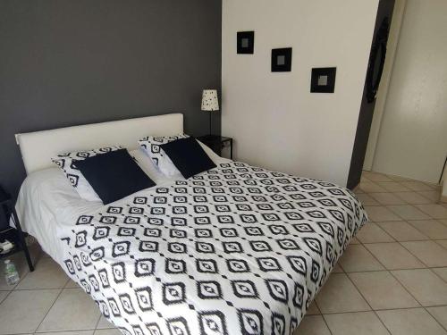 une chambre avec un lit avec une couette noire et blanche dans l'établissement Villa spacieuse avec piscine chauffée, jardin et terrasse à Petit-Piquey - FR-1-736-9, à Lège-Cap-Ferret