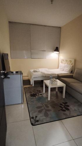 a living room with a couch and a table at Regular Room - Shared Bathroom in Abu Dhabi