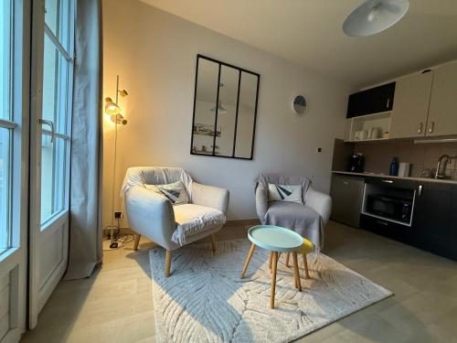 un salon avec deux chaises et une table dans l'établissement Appartement T2 vue sur la rivière avec garage privatif - Port de Saint-Goustan, à Auray